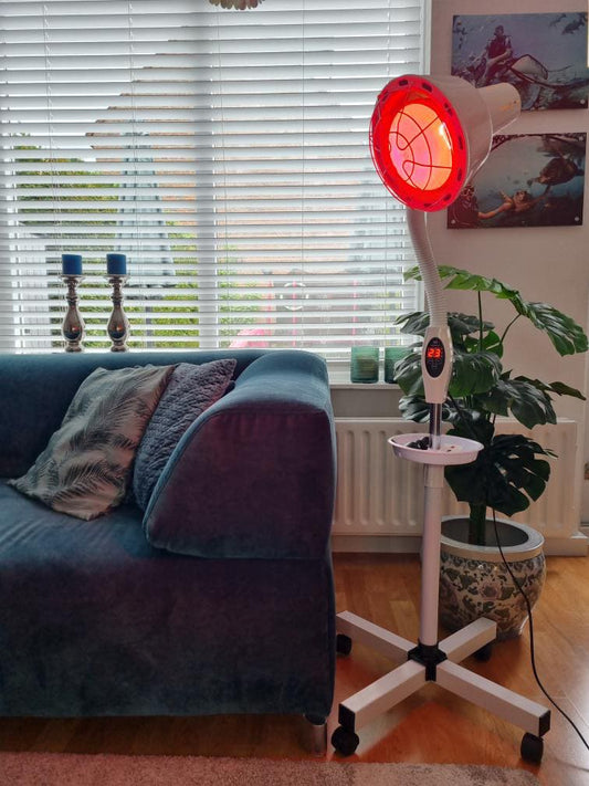 Infraroodlamp op statief in woonkamer voor pijn- en huidtherapie